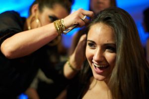 A young girl getting hair extensions from a female hair stylist